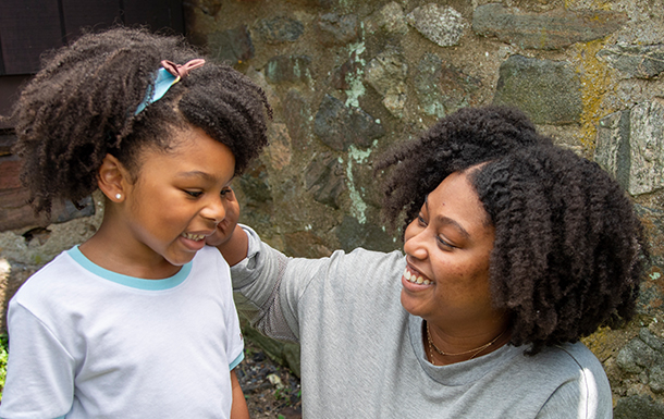 Mother and daughter holding hands and looking at each other